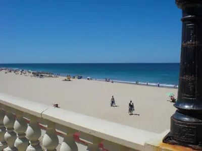 a view of a beach with people walking on the sand at Caracola Wohnung in Chipiona