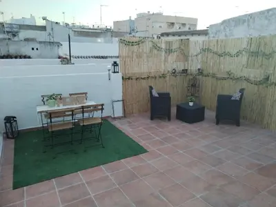 a patio with a table and chairs on a roof at Apartamentos La Campana 1 in Jerez de la Frontera