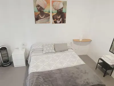 a bedroom with a bed and a poster on the wall at Apartamentos La Campana 1 in Jerez de la Frontera