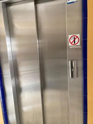 a metal elevator with a sign on it at Apartamento Plata Real in Sanlúcar de Barrameda