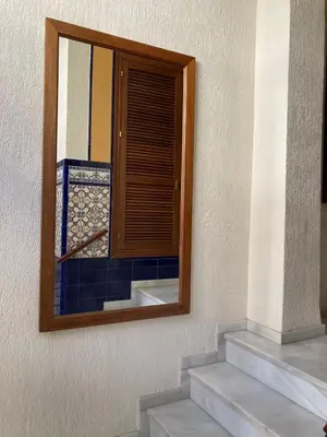 a mirror on the side of a building with stairs at Apartamento Plata Real in Sanlúcar de Barrameda