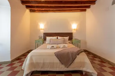 a bedroom with a large bed with two night stands at La Casita Beneroso in Alcalá de los Gazules