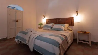 a bedroom with a large bed with two pillows at La Casita Beneroso in Alcalá de los Gazules