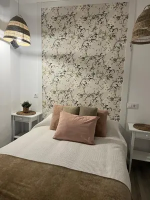 a bedroom with a bed with a floral wallpaper at Estudios Los Sueños de Ana in Jerez de la Frontera