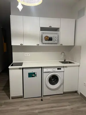 a kitchen with a washing machine and a microwave at Estudios Los Sueños de Ana in Jerez de la Frontera