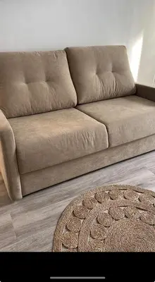 a brown couch in a living room with a rug at Estudios Los Sueños de Ana in Jerez de la Frontera