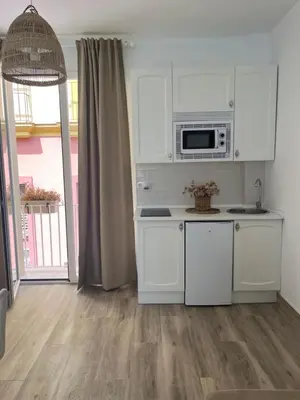 a kitchen with white cabinets and a microwave at Estudios Los Sueños de Ana in Jerez de la Frontera