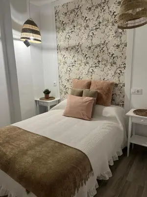 a bedroom with a bed with a floral wallpaper at Estudios Los Sueños de Ana in Jerez de la Frontera