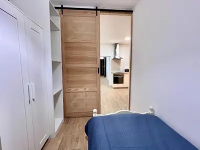 a small bedroom with a door leading to a kitchen at Apartamentos La Albariza Jerez Centro in Jerez de la Frontera