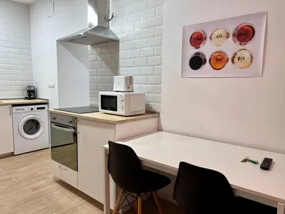 a kitchen with a table and chairs and a microwave at Apartamentos La Albariza Jerez Centro in Jerez de la Frontera
