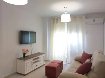 a living room with a couch and a flat screen tv at Centro de Sanlúcar, La Plata 23 in Sanlúcar de Barrameda