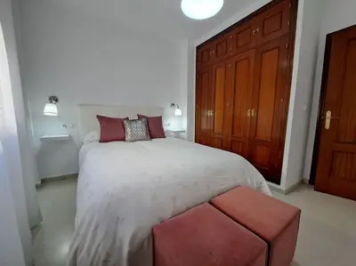 a bedroom with a large bed with red pillows at Centro de Sanlúcar, La Plata 23 in Sanlúcar de Barrameda