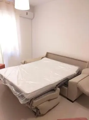 a hospital bed in a room next to a couch at Centro de Sanlúcar, La Plata 23 in Sanlúcar de Barrameda
