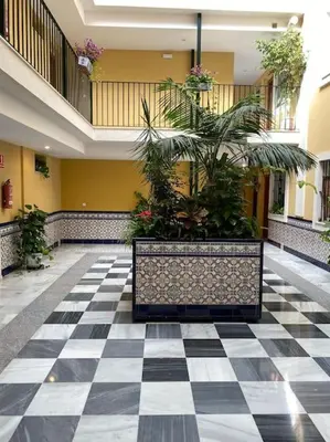 a lobby with a black and white checkered floor with plants at Centro de Sanlúcar, La Plata 23 in Sanlúcar de Barrameda