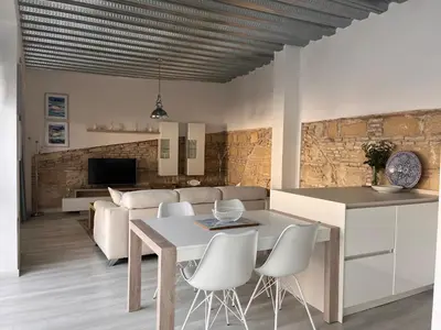 a kitchen and living room with a table and chairs at Casa Nuna Modern Loft with Private Garden Terrace in Jerez de la Frontera