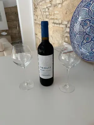 a bottle of wine and two glasses on a table at Casa Nuna Modern Loft with Private Garden Terrace in Jerez de la Frontera