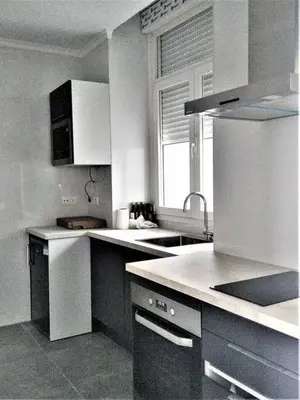 a kitchen with white cabinets and a sink and a window at Casa Palacio Argüeso in Sanlúcar de Barrameda