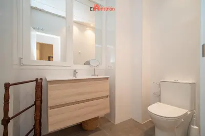 a bathroom with a toilet and a sink and a mirror at El Anfitrión - Argüeso apartamento 3 in Sanlúcar de Barrameda