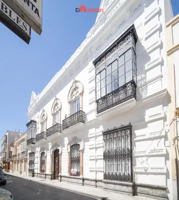 a white building with windows and balconies on a street at El Anfitrión - Argüeso apartamento 3 in Sanlúcar de Barrameda