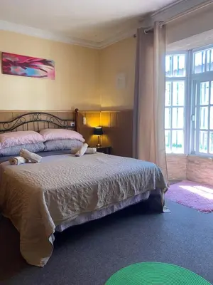 a bedroom with a bed and a large window at Villa El Bomberito in Chiclana de la Frontera