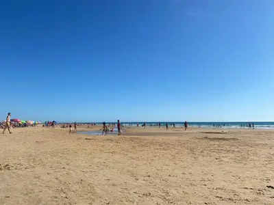 a group of people walking on a beach at Villa El Bomberito in Chiclana de la Frontera