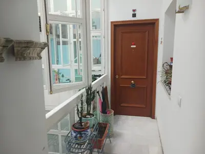 a hallway with a staircase with a wooden door at Habitación privada con baño. in Cádiz