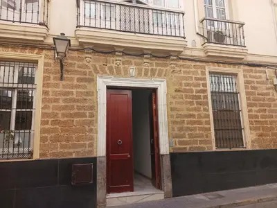 a red door on the side of a brick building at Habitación privada con baño. in Cádiz