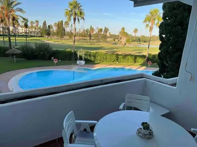 a patio with a pool and a table and chairs at GINVA - Costa Ballena & Playa del Infante in Chipiona
