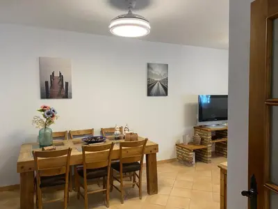 a dining room with a table and chairs and a television at Chalet La Garrocha in Chiclana de la Frontera