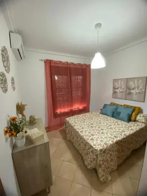 a bedroom with a bed and a table and a window at Chalet La Garrocha in Chiclana de la Frontera