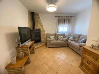 a living room with a couch and a flat screen tv at Chalet La Garrocha in Chiclana de la Frontera