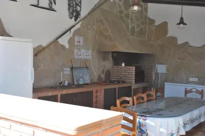 a kitchen with a table and a stone wall at Chalet La Garrocha in Chiclana de la Frontera