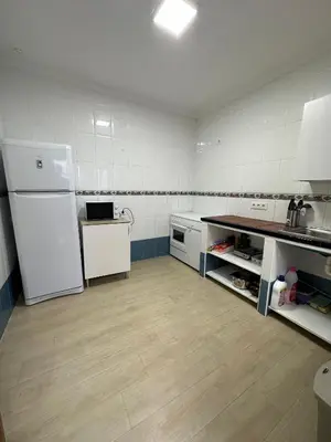 a kitchen with a white refrigerator and a sink at Chipiona Suites A in Chipiona