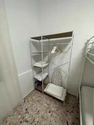 a white closet with a shelf and a bed at Chipiona Suites A in Chipiona