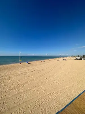 a beach with a flag in the sand and the ocean at Chipiona Suites B in Chipiona