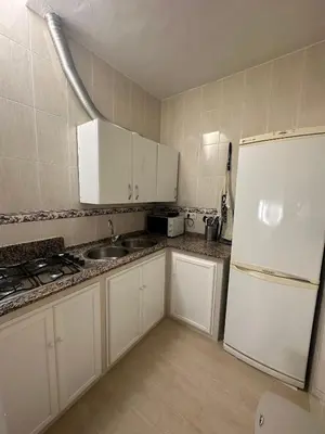 a kitchen with white cabinets and a white refrigerator at Chipiona Suites B in Chipiona