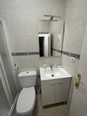 a bathroom with a white toilet and a sink at Chipiona Suites B in Chipiona