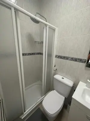 a bathroom with a white toilet and a shower at Chipiona Suites B in Chipiona