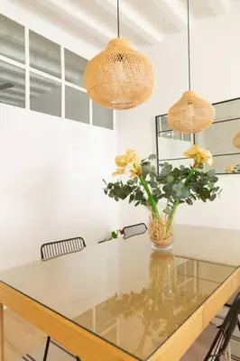 a dining room table with a vase of flowers on it at Tanguillo by Gades Gestión in Cádiz