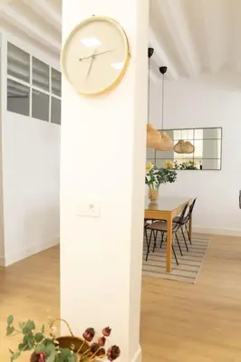 a clock on a column in a room with a table at Tanguillo by Gades Gestión in Cádiz