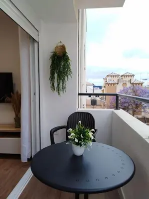 a table and a chair in a room with a window at Avda de las Piletas, segunda línea de playa in Sanlúcar de Barrameda