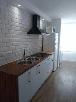 a kitchen with a sink and a refrigerator at Avda de las Piletas, segunda línea de playa in Sanlúcar de Barrameda