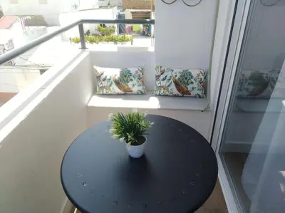 a black table with a potted plant on a balcony at Avda de las Piletas, segunda línea de playa in Sanlúcar de Barrameda