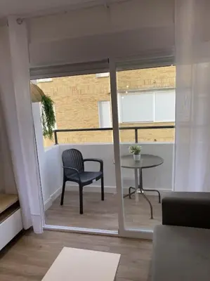 a room with a chair and a table and a window at Avda de las Piletas, segunda línea de playa in Sanlúcar de Barrameda