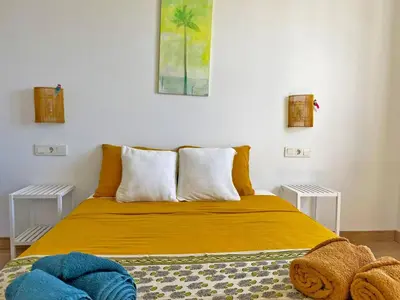 a bedroom with a yellow bed with two tables at Apartamento Ronda de la Luz - Ole Solutions in Jerez de la Frontera