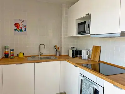 a kitchen with white cabinets and a sink at Apartamento Ronda de la Luz - Ole Solutions in Jerez de la Frontera
