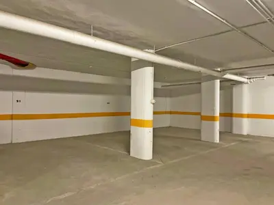 an empty parking garage with white columns and orange stripes at Apartamento Ronda de la Luz - Ole Solutions in Jerez de la Frontera