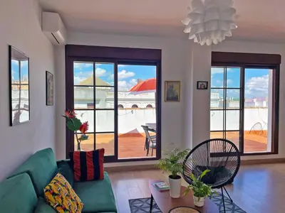 a living room with a green couch and a table at Apartamento Ronda de la Luz - Ole Solutions in Jerez de la Frontera