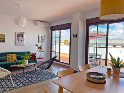 a living room with a green couch and a table at Apartamento Ronda de la Luz - Ole Solutions in Jerez de la Frontera