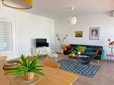 a living room with a green couch and a table at Apartamento Ronda de la Luz - Ole Solutions in Jerez de la Frontera